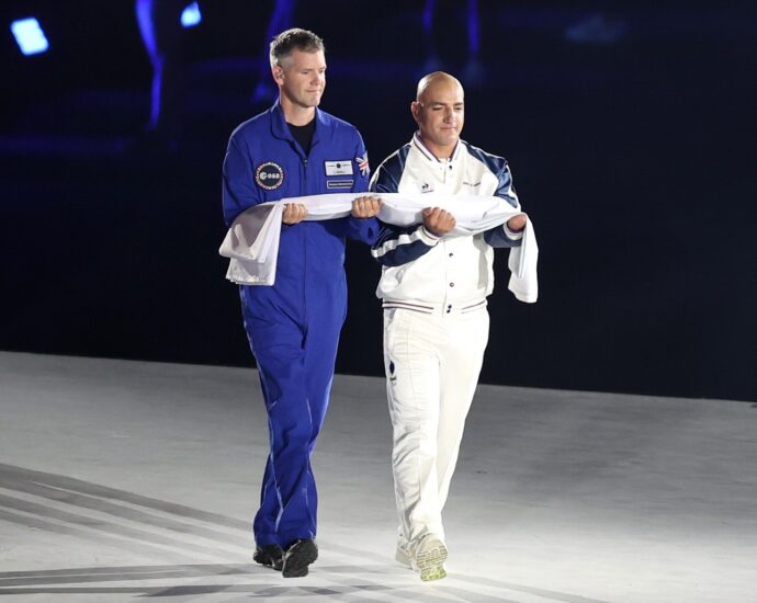 Astronaut John McFall carries Paralympic flag at opening ceremony Aug. 28