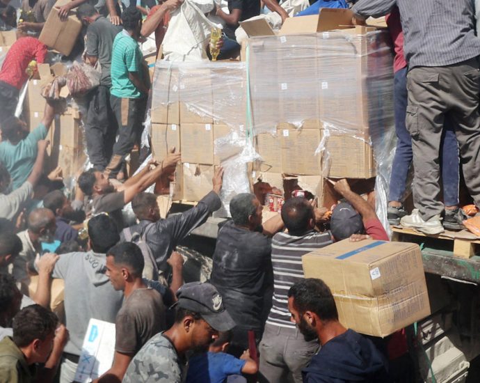 palestinians-crowd-onto-aid-trucks-moving-through-gaza