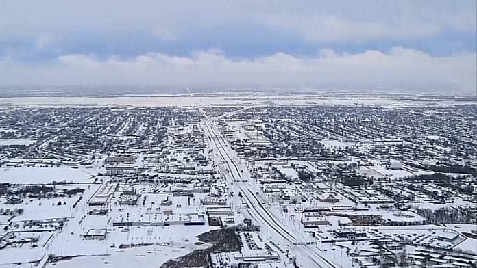 drone-footage-shows-snow-covered-us-cities,-snow-plows-at-work