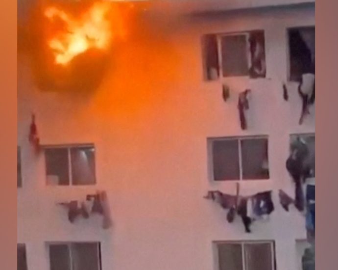 people-climb-from-windows-of-burning-campus-building-in-dakar