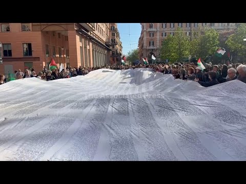 people-march-in-rome-with-a-shroud-bearing-the-names-of-the-children-who-have-died-in-gaza